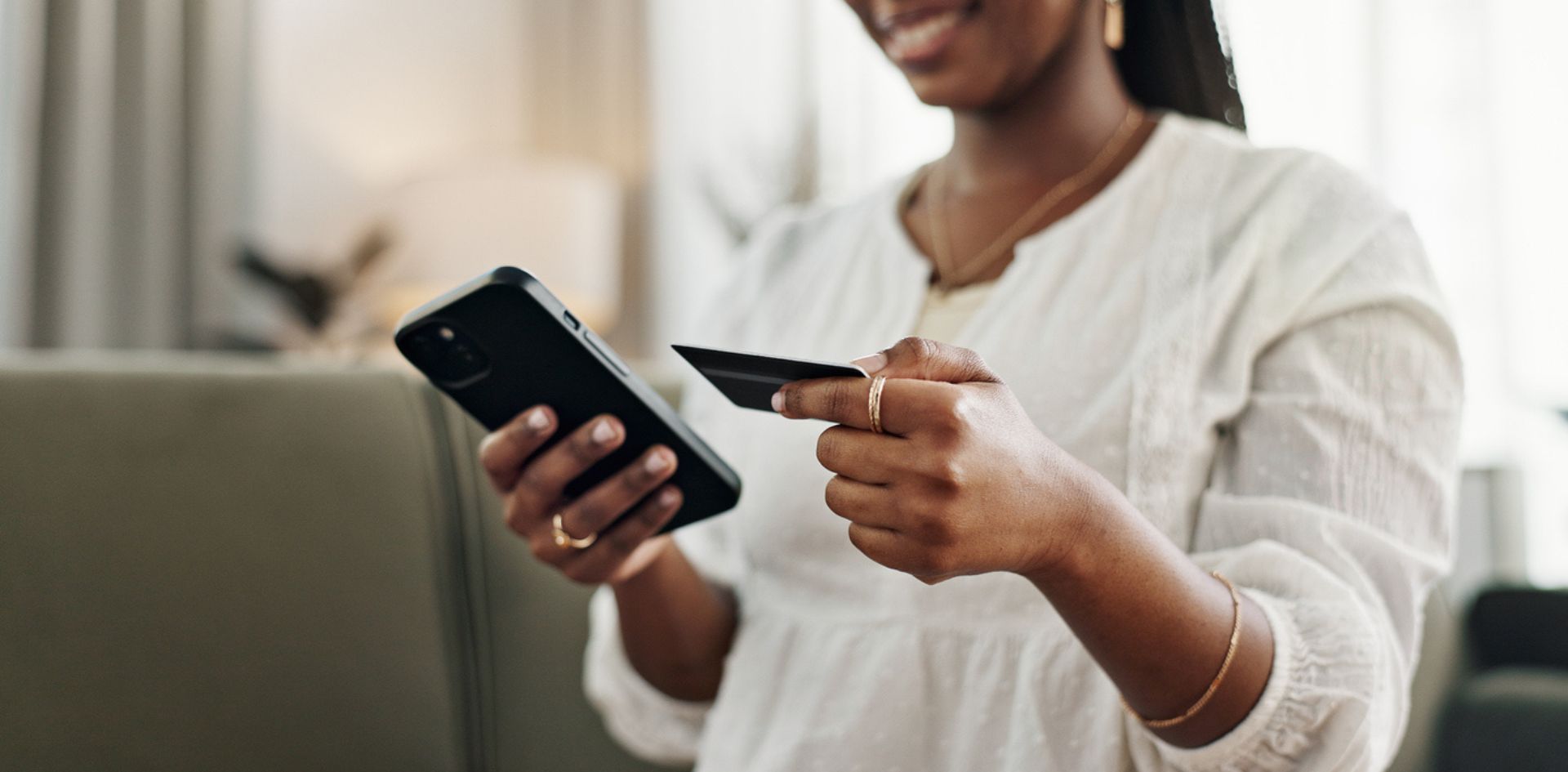 Woman looking at phone and credit card